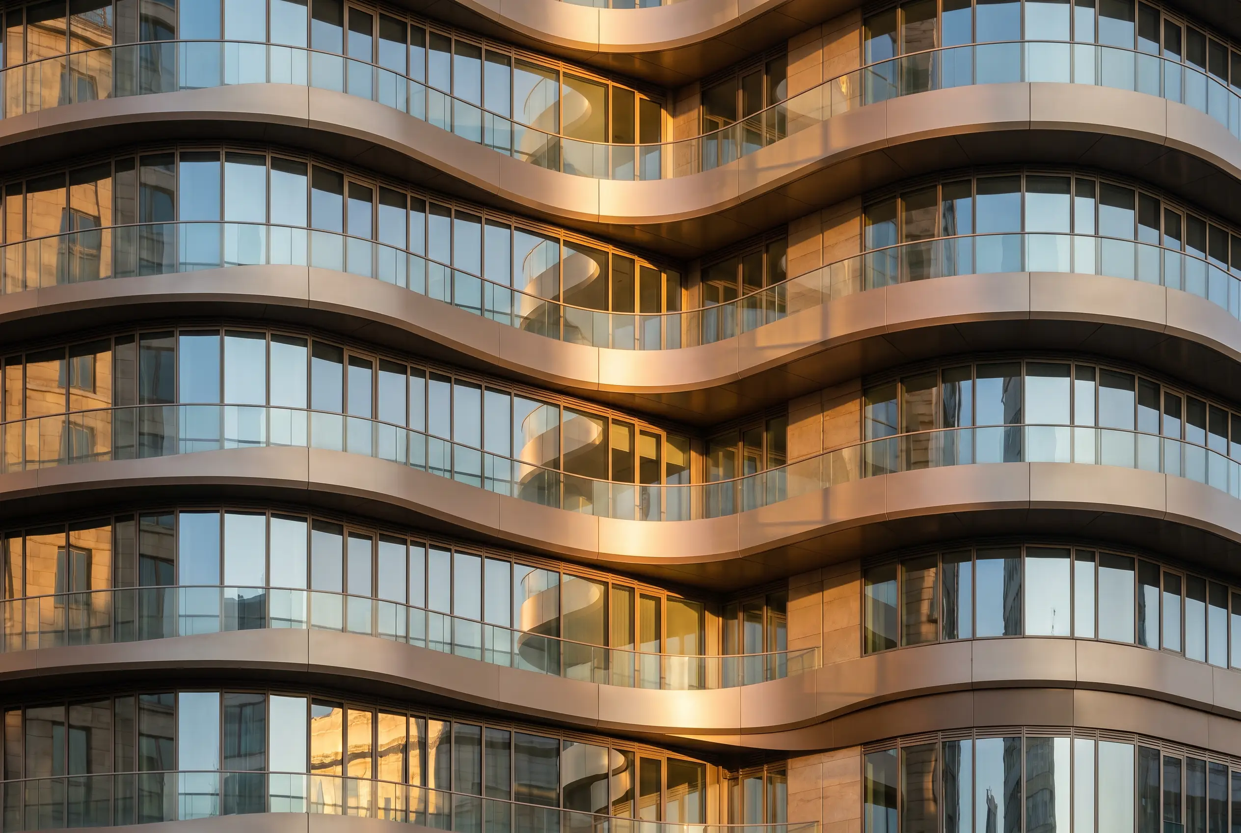 Detail of the curved, rippling balcony bands catching golden light